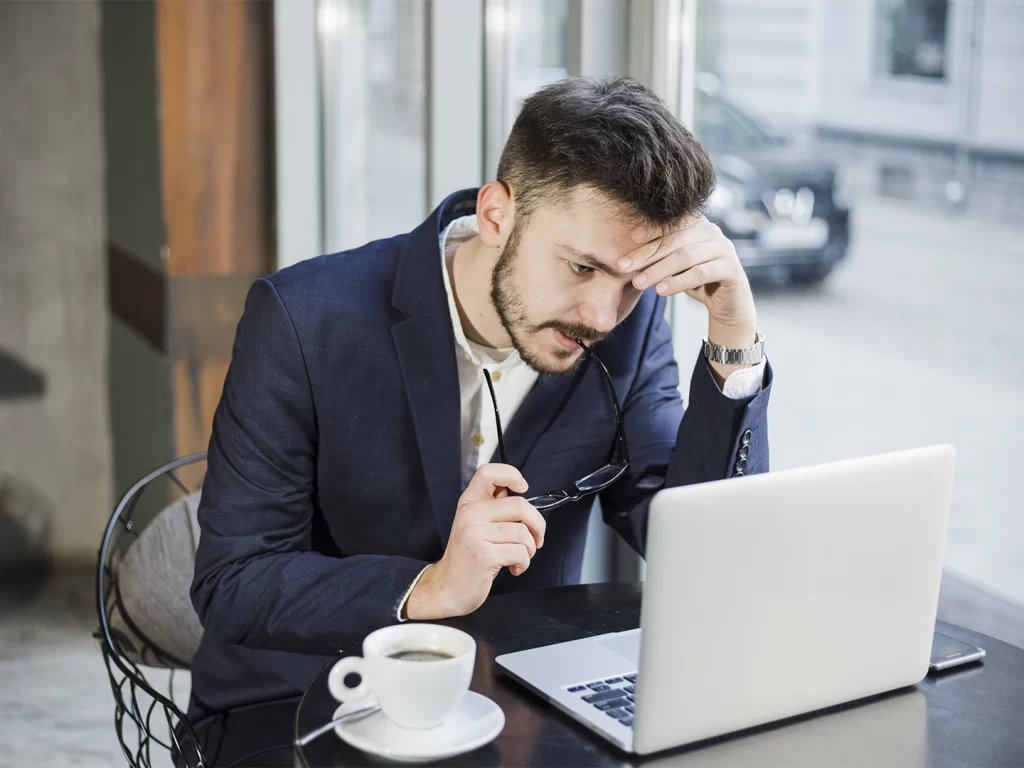 Empresário analisando dados em um computador buscando sair do operacional.
